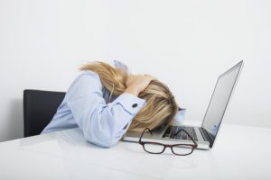 woman with head on laptop frustrated because of not finding writing time