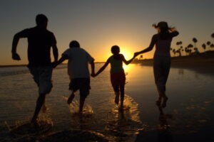 family running on beach